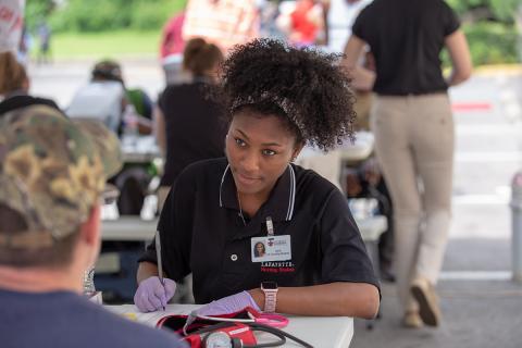 Student nurse works with a client at Giving HOPE community event.