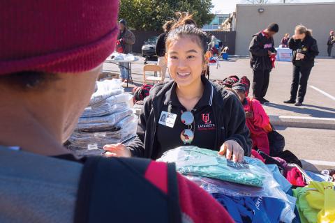 Student offers free clothing to a man during the community outreach event giving H.O.P.E..